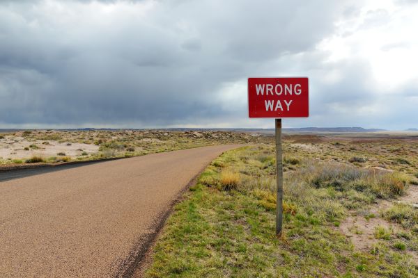 wrong_turn_arizona WRONG WAY sign in Petrified Forest National Park, Arizona, USA. Exploring the American Southwest.
