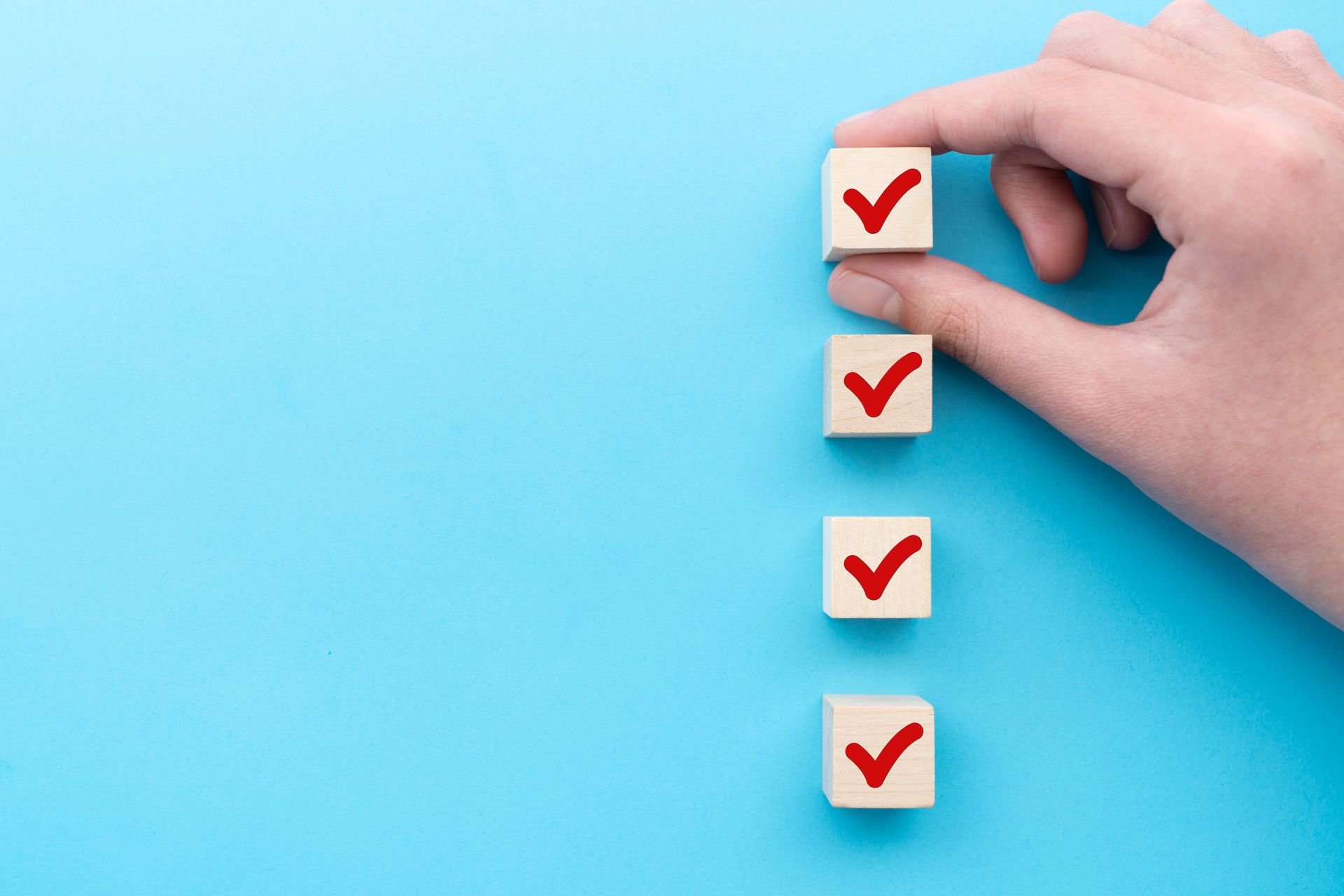 Hand put down the red tick marking wooden cube for checklist or to do list